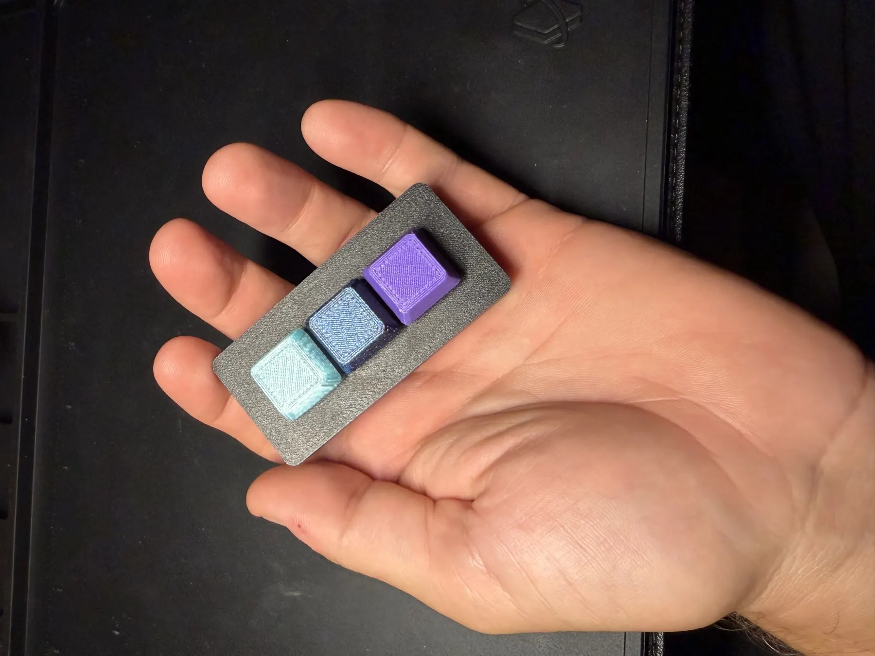 Three-key Passive Clacky held in one hand to show its compact size